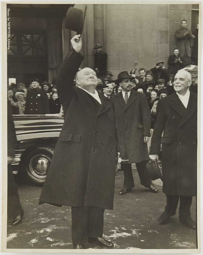 Photograph of Winston Churchill waving his hat at a crowd
