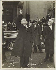 Photograph of Winston Churchill waving his hat at a crowd