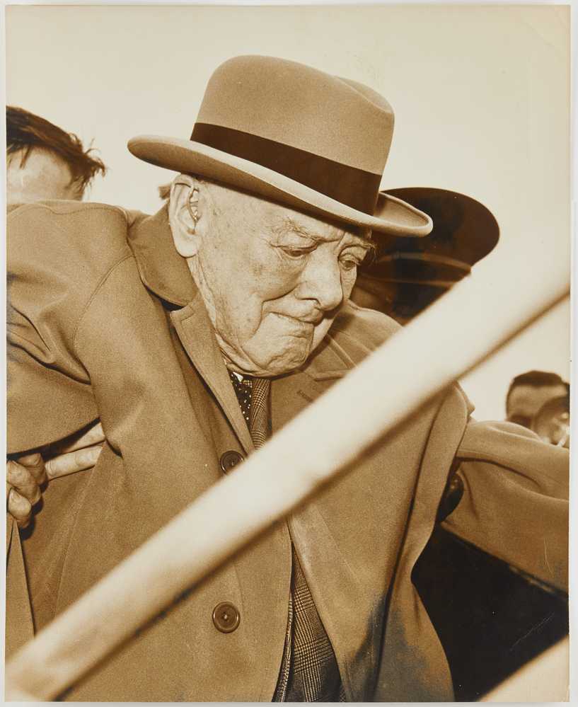 Photograph of Winston Churchill being helped onto a plane